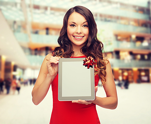 christmas, holidays, technology and people concept - smiling woman in red dress with tablet pc computer over shopping center background