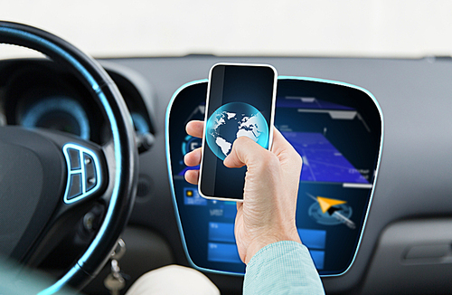 transport, business trip, technology and people concept - close up of young man hand with globe on smartphone screen driving car