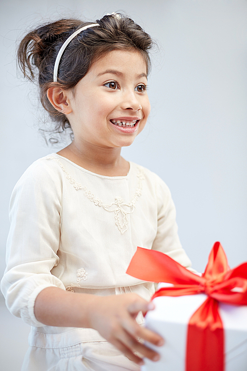 holidays, presents, christmas, childhood and people concept - smiling little girl with gift box at home