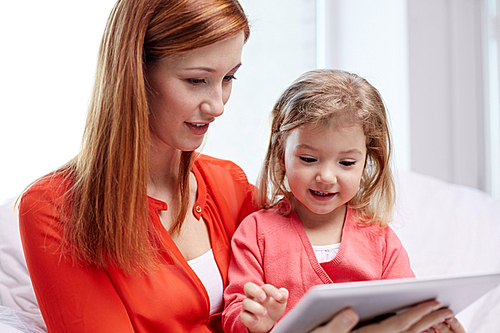 family, children, parenthood, technology and internet concept - happy mother and daughter with tablet pc computer at home