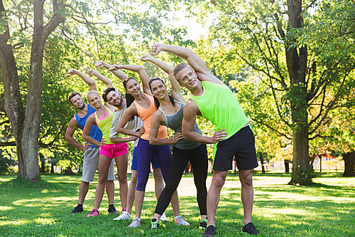 fitness, sport, friendship and healthy lifestyle concept - group of happy teenage friends or sportsmen exercising and stretching hands at boot camp