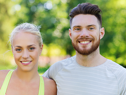 fitness, sport, friendship and healthy lifestyle concept - group of happy teenage friends or sportsmen couple hugging outdoors