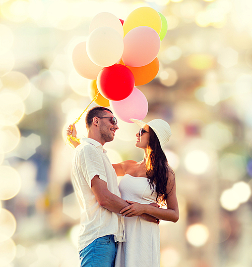 love, wedding, summer, dating and people concept - smiling couple wearing sunglasses with balloons hugging over lights background