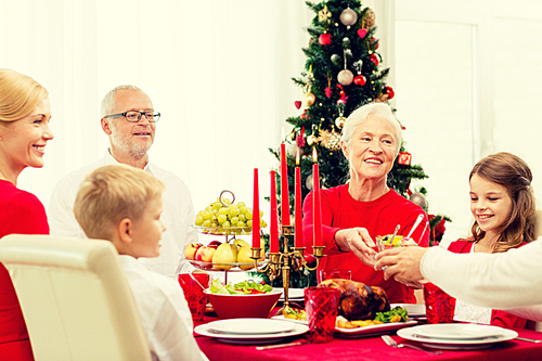 family, holidays, generation, christmas and people concept - smiling family having dinner at home