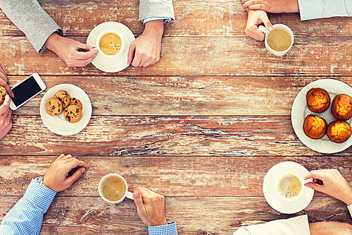 business, people and team work concept - close up of creative team meeting and drinking coffee during lunch in office