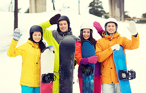 winter, leisure, extreme sport, friendship and people concept - happy friends in helmets with snowboards