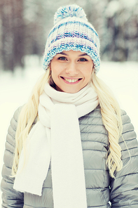 season, christmas and people concept - happy smiling young woman in winter forest