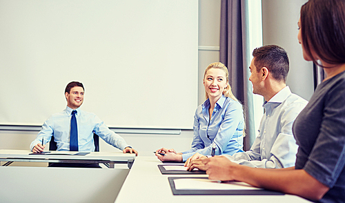 business, people and teamwork concept - group of smiling businesspeople meeting in office