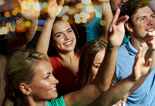 party, holidays, celebration, nightlife and people concept - smiling friends waving hands at concert in club