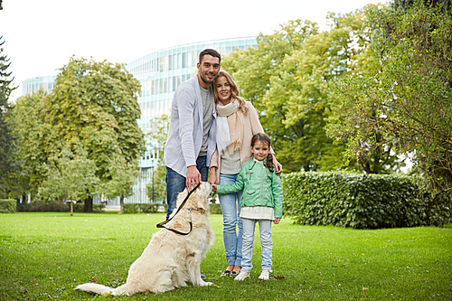 family, pet, domestic animal and people concept - happy family with labrador retriever dog walking in summer park