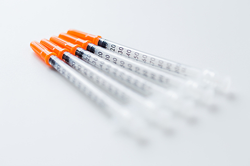 medicine, diabetes and health care concept - close up of insulin syringes on table
