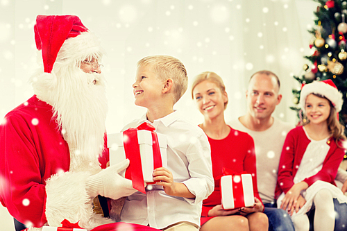 family, holidays, generation, christmas and people concept - smiling family with santa claus and gift boxes at home