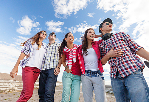 summer holidays and teenage concept - group of smiling teenagers in sunglasses hanging outside