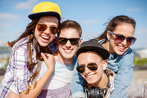 summer holidays and teenage concept - group of smiling teenagers hanging outside