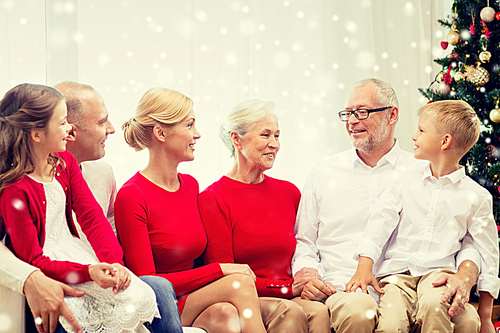 family, holidays, generation, christmas and people concept - smiling family sitting and talking on couch at home