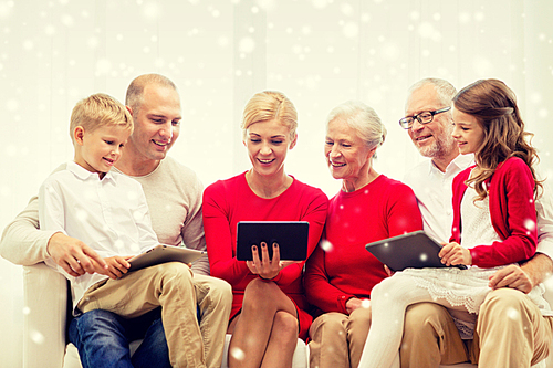 family, holidays, christmas, technology and people concept - smiling family with tablet pc computers sitting on couch at home