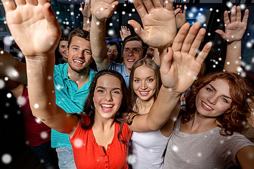 party, holidays, celebration, friends and people concept - smiling friends dancing and waving hands in club