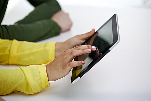 people, technology and internet concept - close up of african american female hands with tablet pc at table