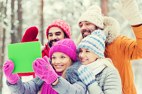 technology, season, friendship and people concept - group of smiling men and women taking selfie tablet pc computer in winter forest