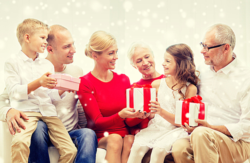 family, holidays, generation, christmas and people concept - smiling family giving each other presents  at home