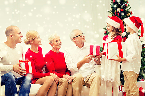 family, holidays, generation, christmas and people concept - smiling family with gift boxes sitting on couch at home