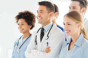 hospital, profession, people and medicine concept - group of happy doctors wit stethoscopes or mentor with interns at hospital