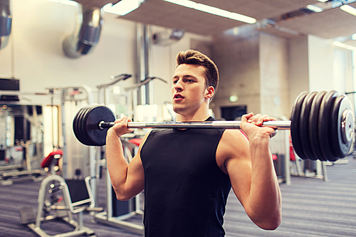 sport, bodybuilding, lifestyle and people concept - young man with barbell flexing muscles in gym