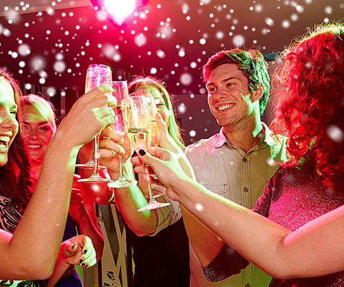 new year party, holidays, celebration, nightlife and people concept - smiling friends clinking glasses of non-alcoholic champagne in club and snow effect