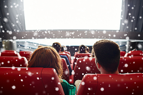 cinema, entertainment, leisure and people concept - couple watching movie in theater from back over snowflakes