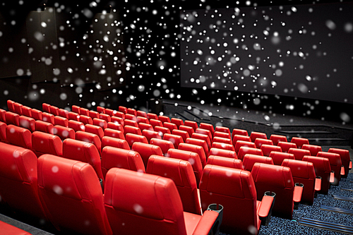 entertainment and leisure concept - movie theater or cinema empty auditorium with red seats over snowflakes