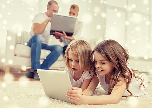 family, home, technology and people - smiling mother, father and little girls with tablet pc computer over snowflakes background