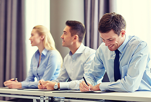 business, people and teamwork concept - group of smiling businesspeople meeting on presentation in office