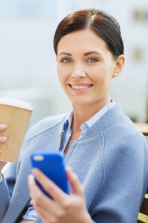 business and people concept - young smiling woman with smartphone sitting on bench and drinking coffee in city