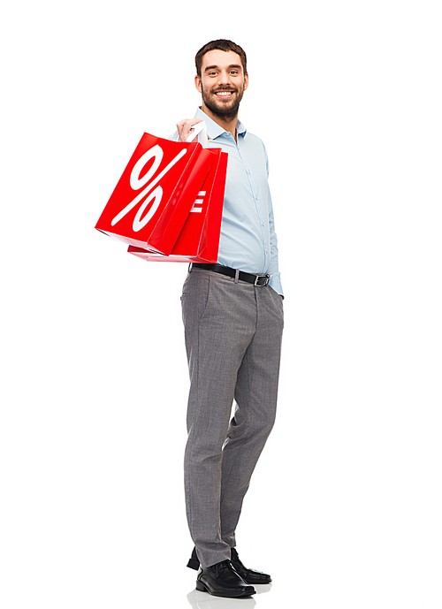 people, sale, discount and holidays concept - smiling man holding red shopping bags with percentage sign