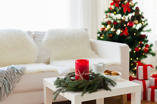 holidays, winter, celebration and still life concept - sofa, table and christmas tree with gifts at home