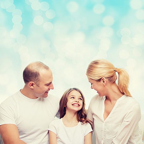 family, childhood, holidays and people - smiling mother, father and little girl over blue lights background