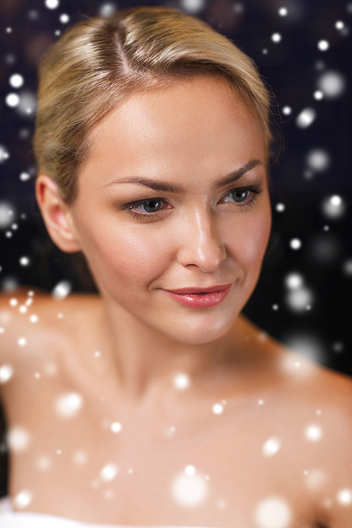 people, beauty, spa, healthy lifestyle and relaxation concept - close up of beautiful young woman in bath towel at sauna with snow effect
