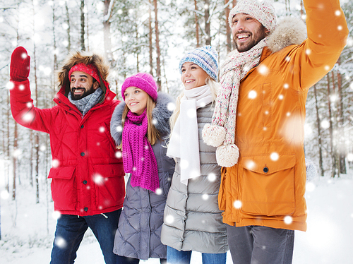 love, relationship, season, friendship and people concept - group of smiling men and women waving hands in winter forest