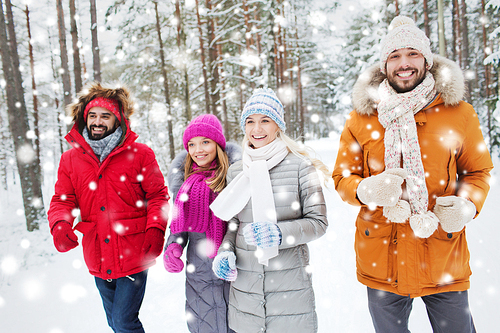 love, relationship, season, friendship and people concept - group of smiling men and women running in winter forest