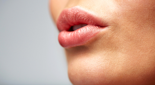 beauty, people, make-up and plastic surgery concept - close up of young woman lips