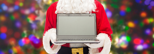 christmas, advertisement, technology, and people concept - close up of santa claus with laptop computer over lights background