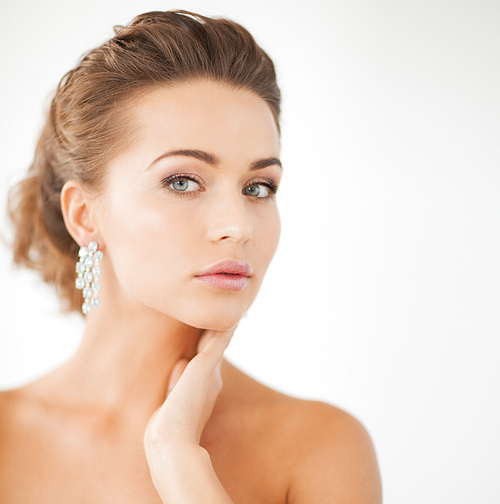 close up of beautiful woman wearing shiny diamond earrings