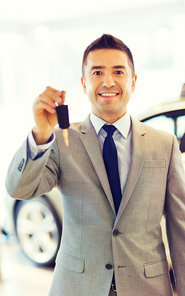 auto business, car sale, consumerism and people concept - happy man showing key at auto show or salon