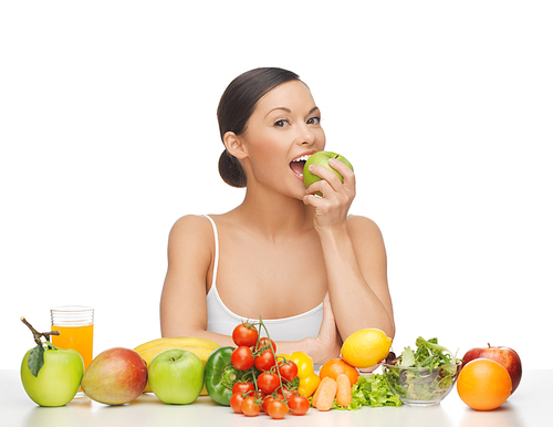 woman eating apple with lot of fruits and vegetables