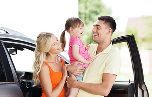 family, transport, leisure and people concept - happy man, woman and little girl with car laughing at home parking space