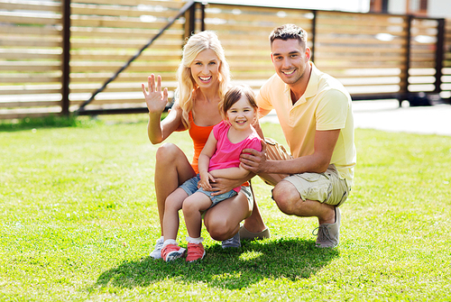 family, happiness, adoption, gesture and people concept - happy family waving hand outdoors