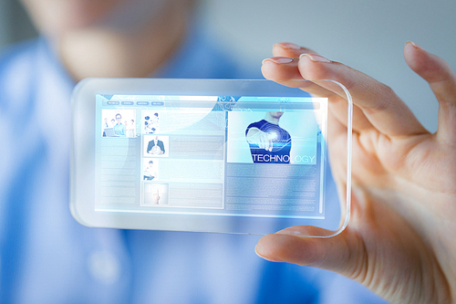 business, technology, internet and people concept - close up of woman hand holding and showing transparent smartphone with web site page on screen