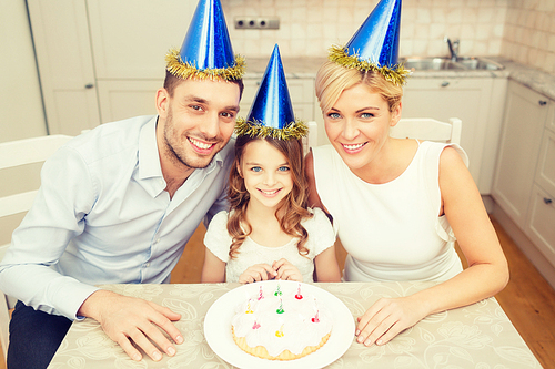 celebration, family, holidays and birthday concept - happy family in blue hats with cake