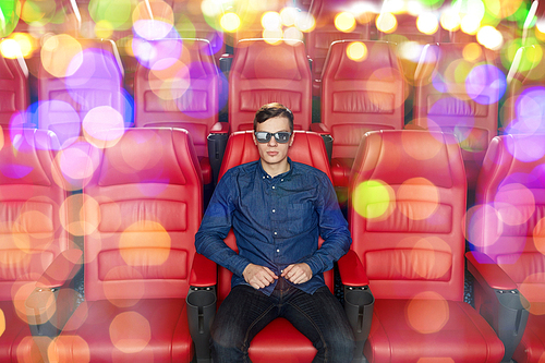 cinema, technology, entertainment and people concept - young man with 3d glasses watching movie alone in empty theater auditorium