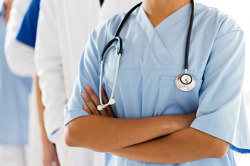 health care, profession, people and medicine concept - close up of african female doctor or nurse with stethoscope over group of medics at hospital